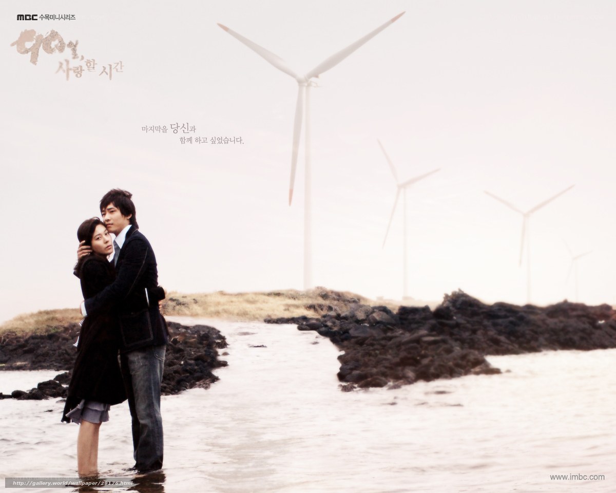 Couple embracing by wind turbines