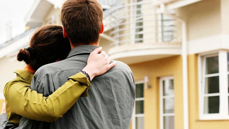couple embracing in front of house