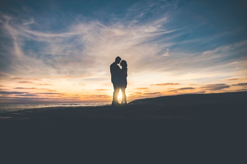 Couple Embracing on Beach — Blue, Romantic, Sunset, Photograph, Ocean