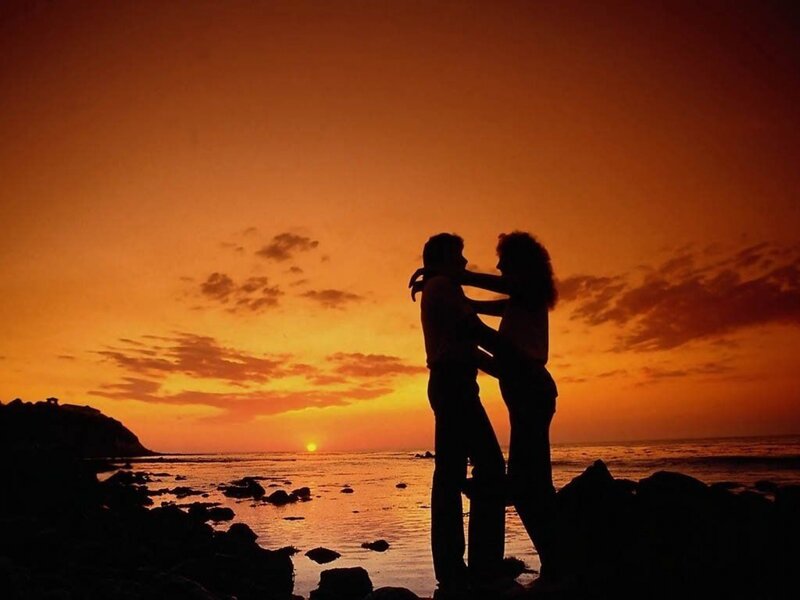Couple Embracing on Beach — Orange, Romantic, Sunset, Photograph, Ocean, Rocks