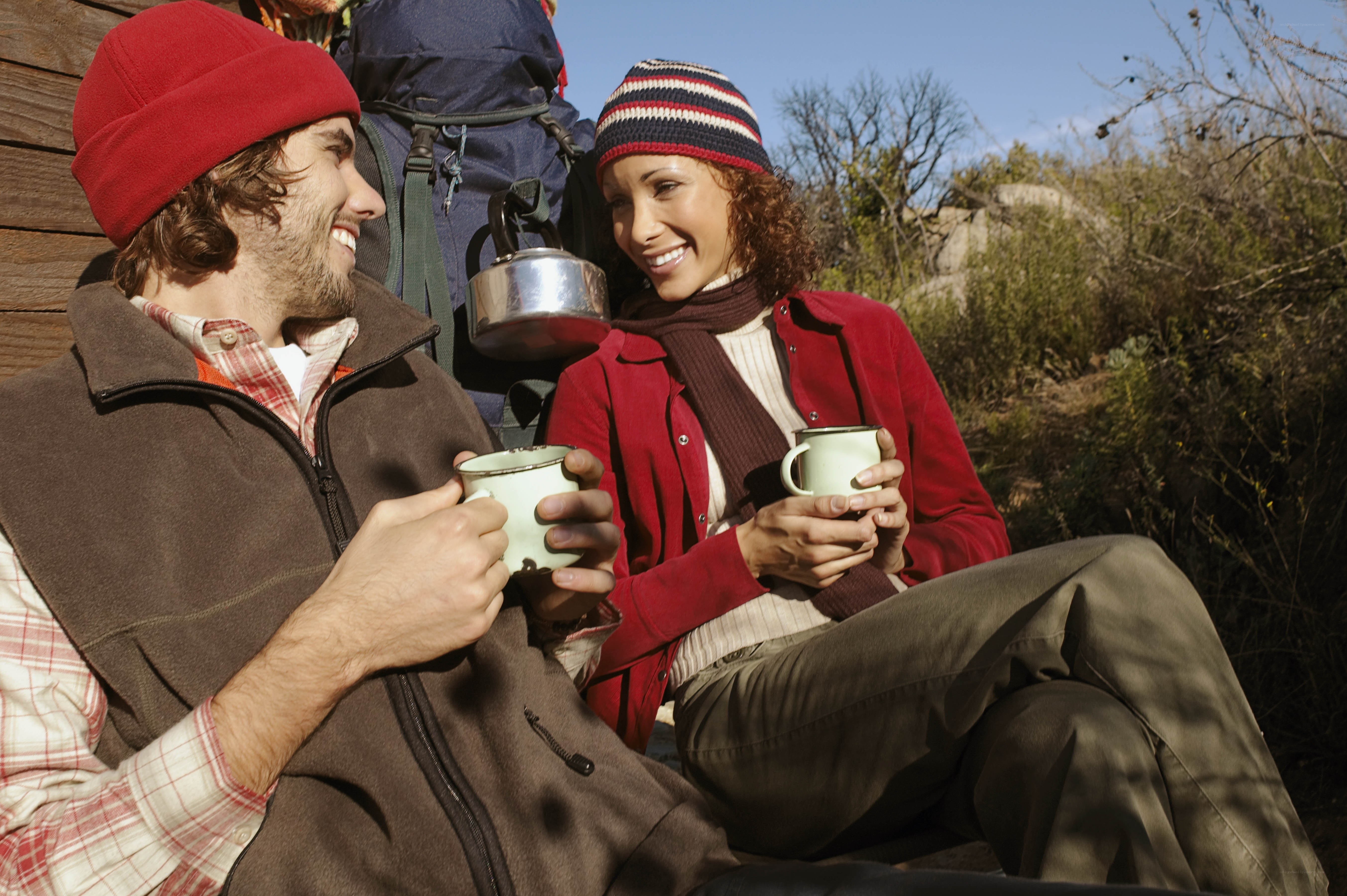 Couple enjoying hot drinks on hike