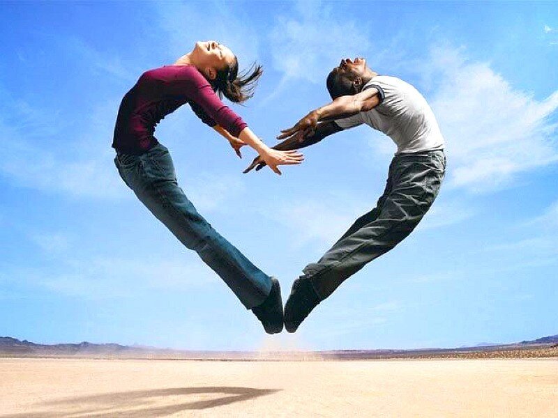 Couple forming heart shape in desert