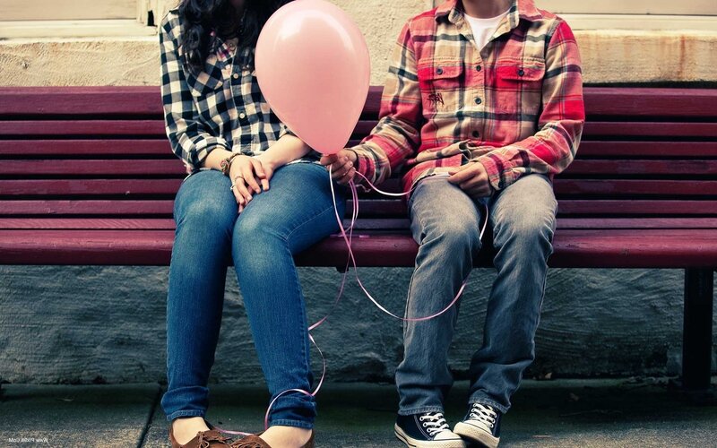 Couple holding a pink balloon