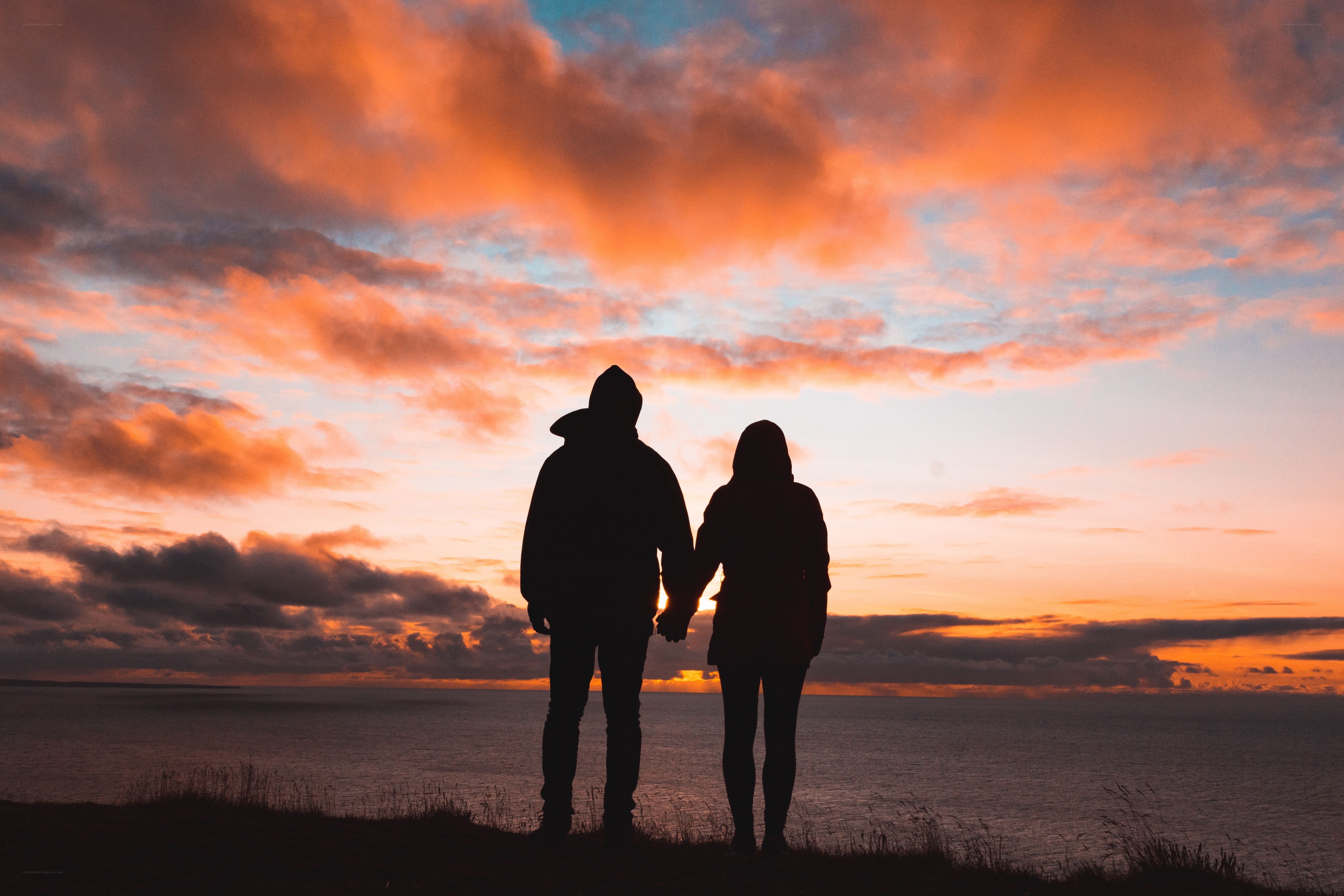 Couple holding hands at sunset