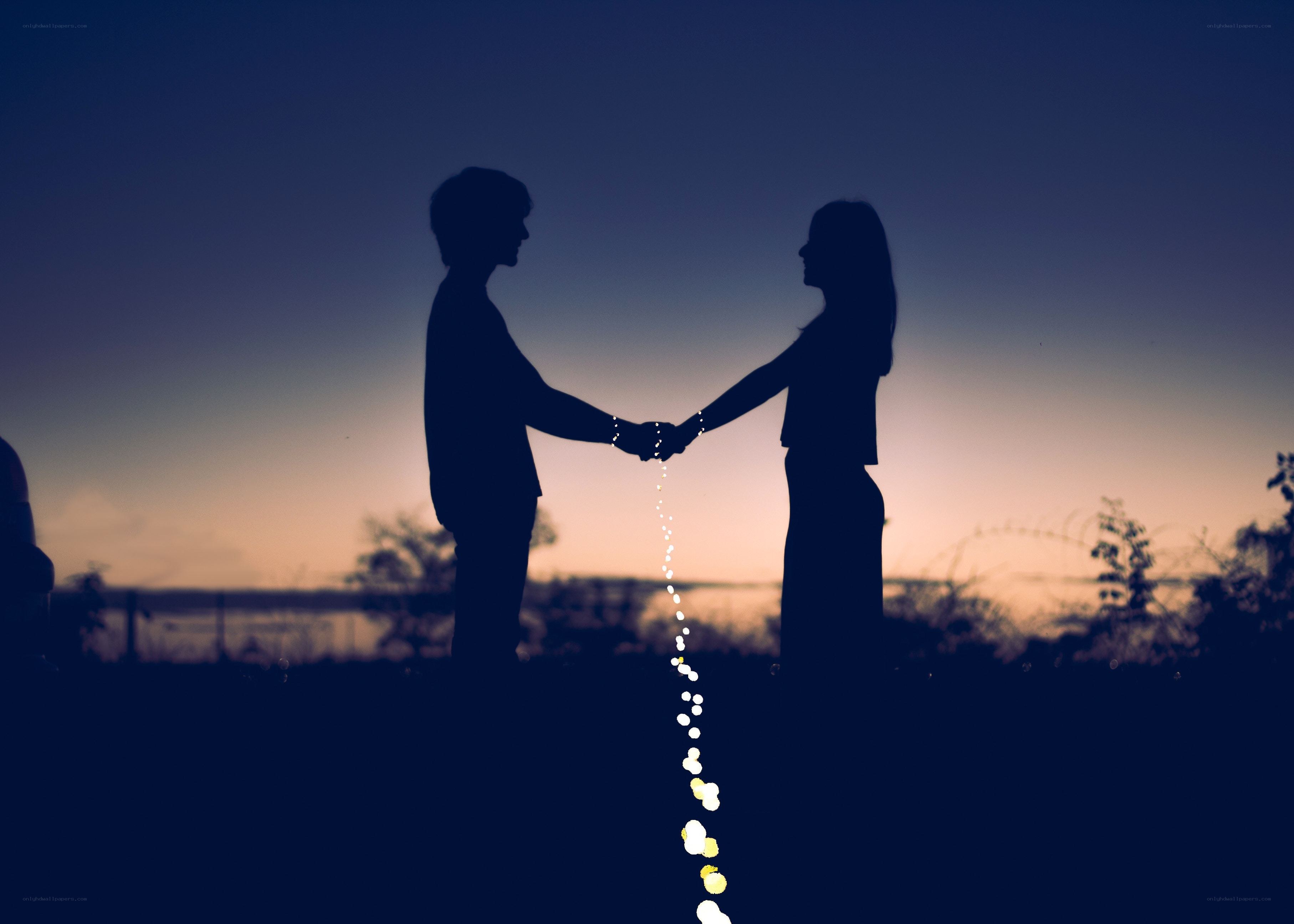 Couple holding hands at sunset