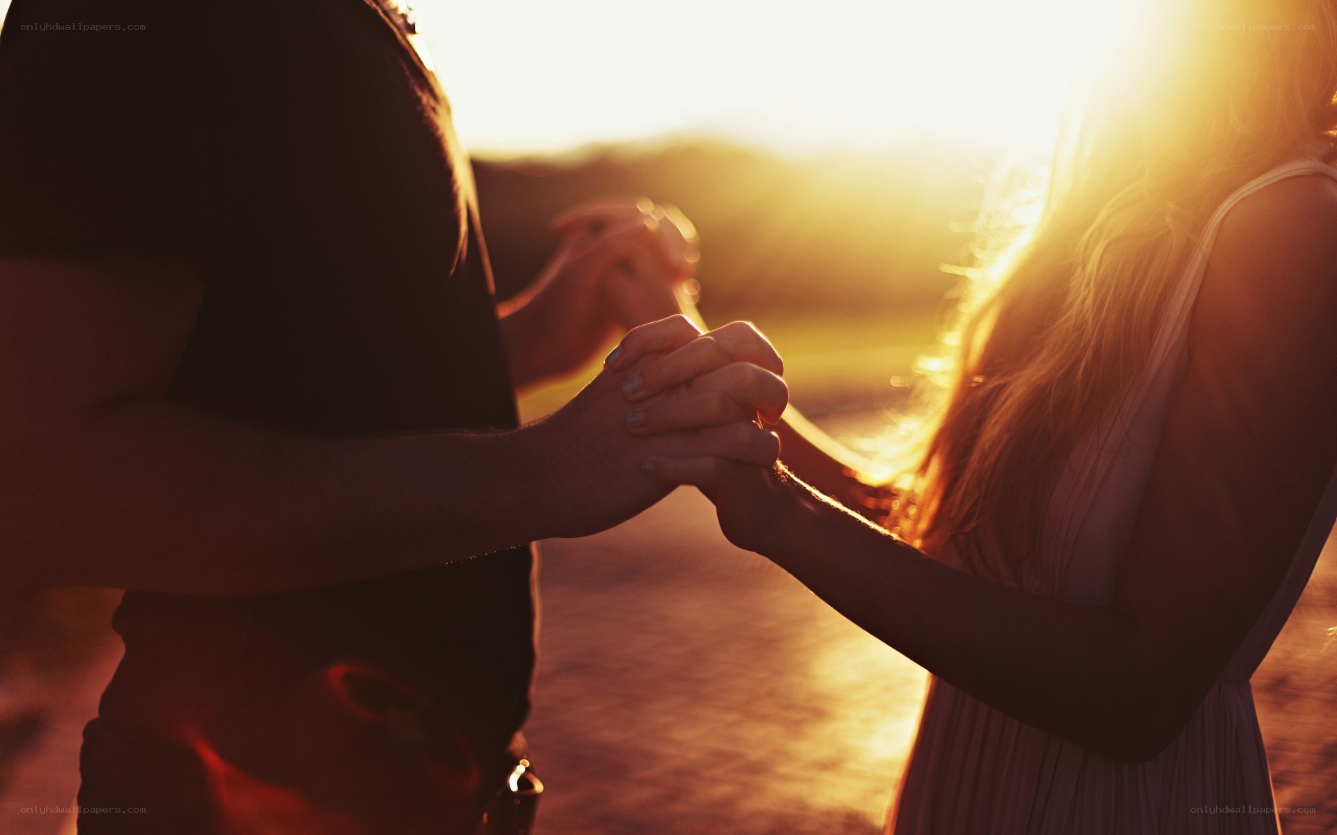 couple holding hands at sunset