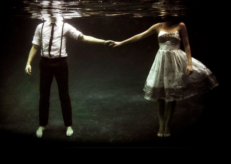 Couple holding hands underwater