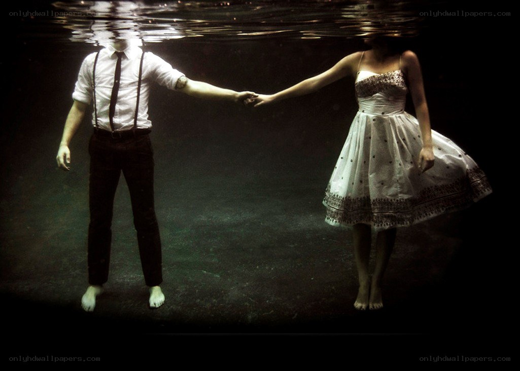 Couple holding hands underwater