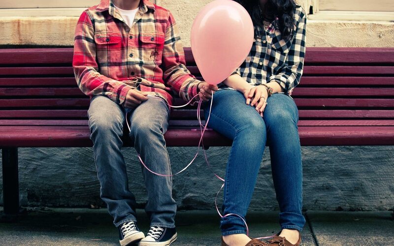 Couple holding pink balloon