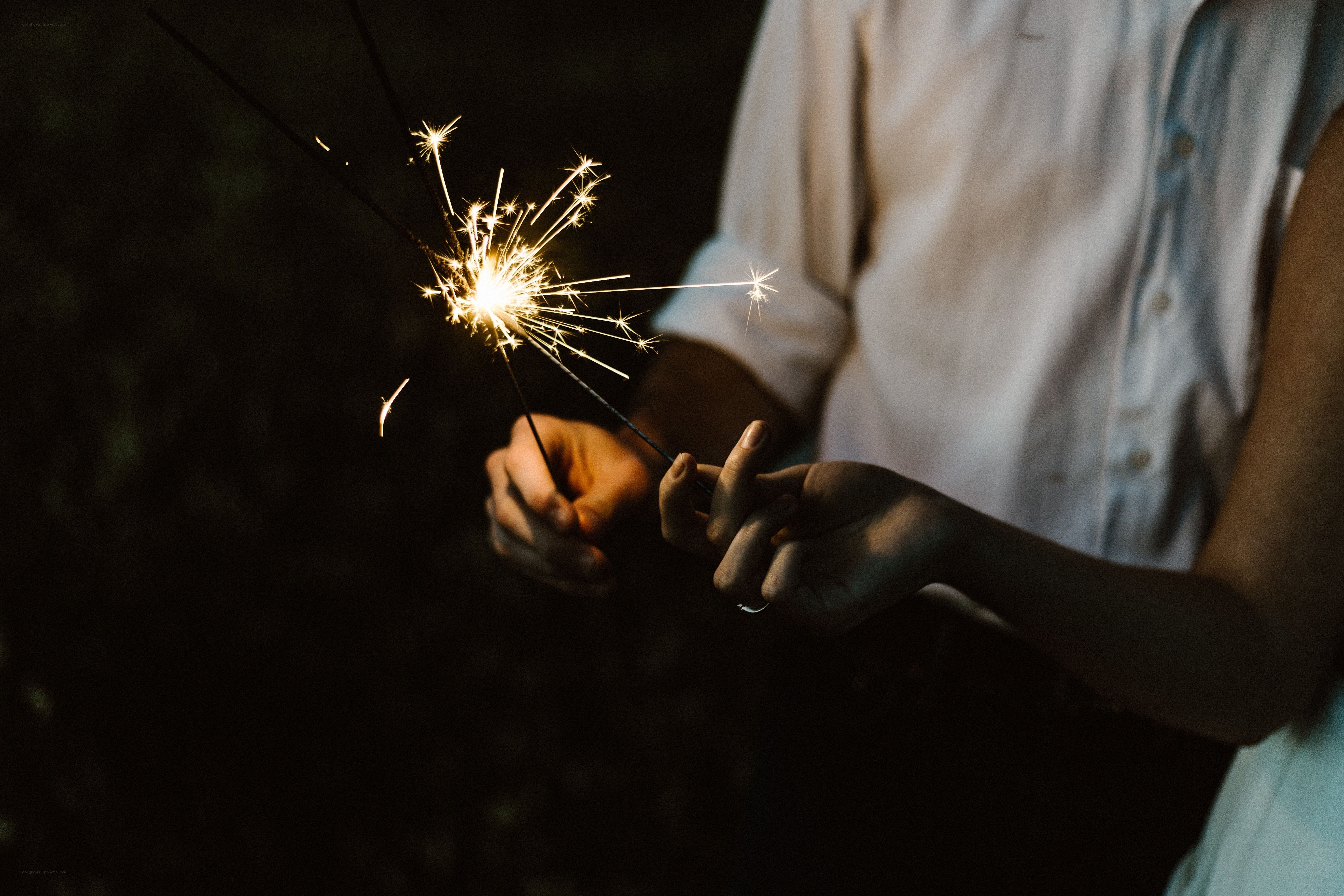 Couple holding sparklers at night