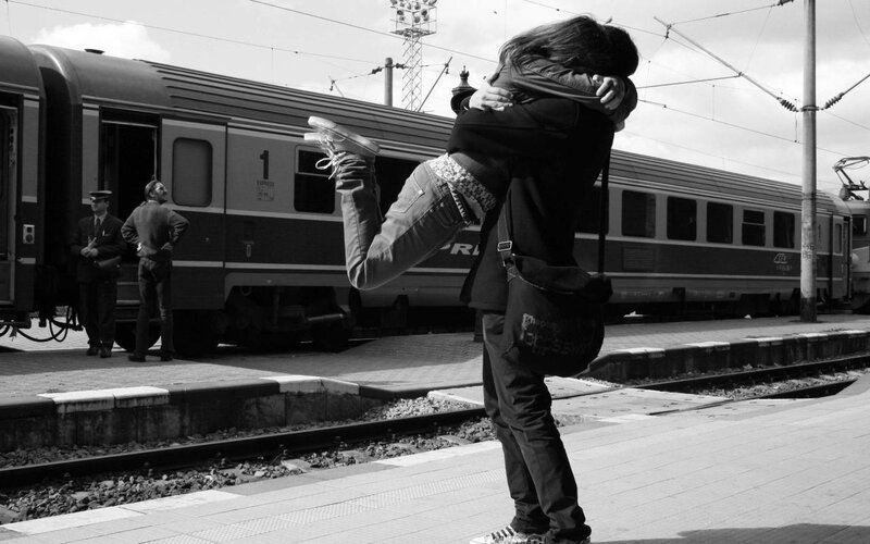 Couple hugging at train station