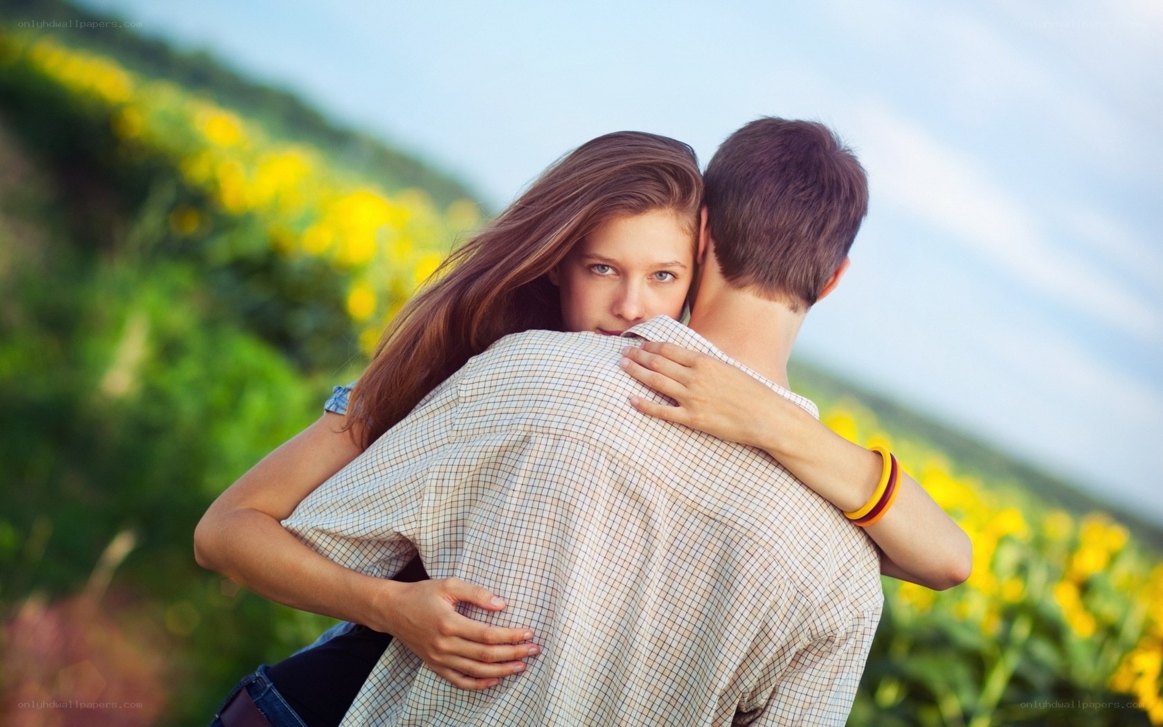 couple hugging in field
