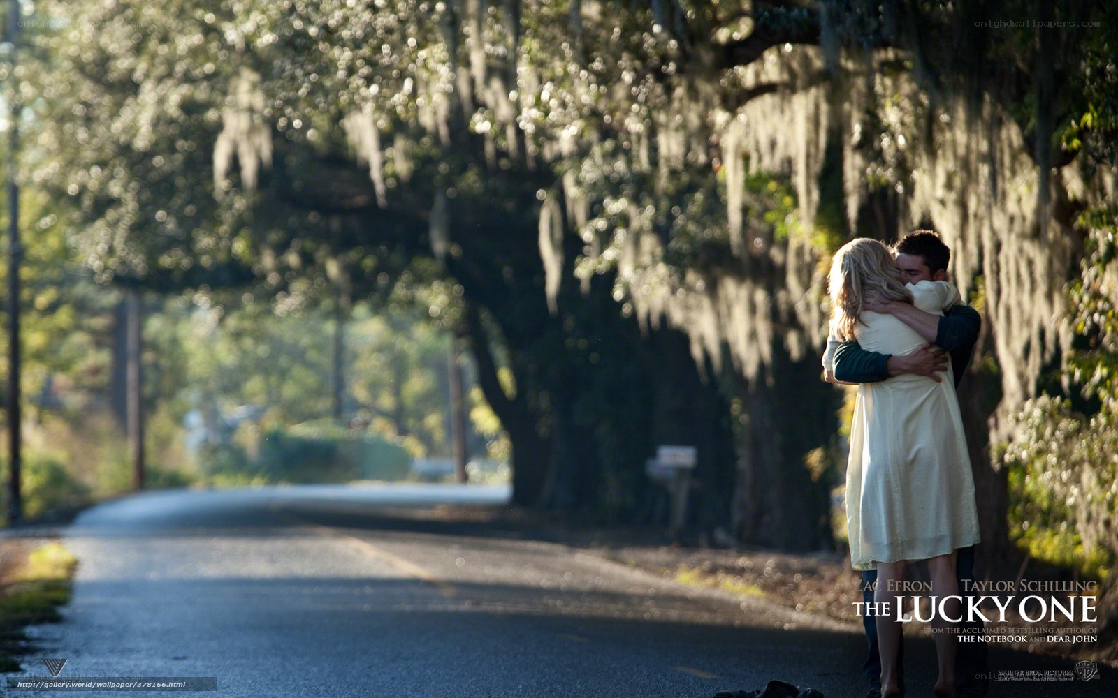 couple hugging on a tree-lined road