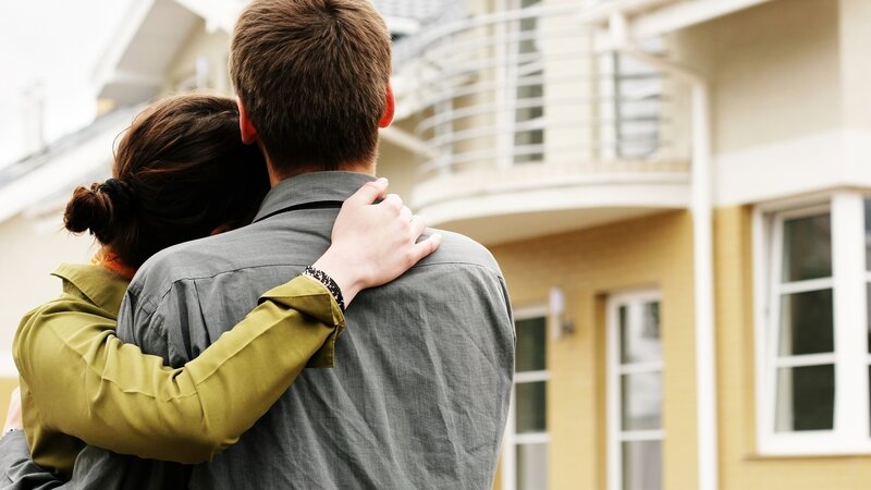Couple Hugging Outside House
