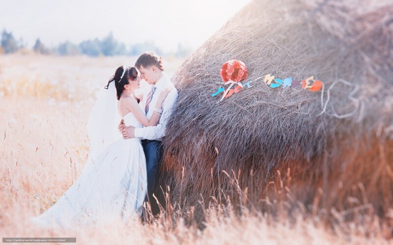 Couple in a field with hay bale