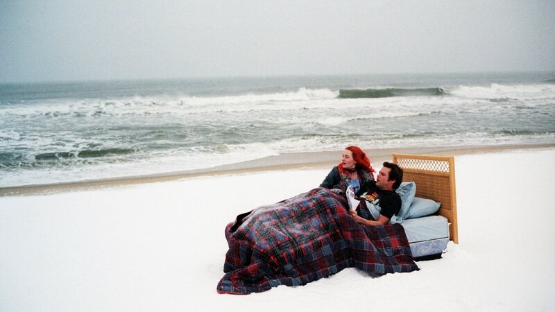 Couple in bed on snowy beach