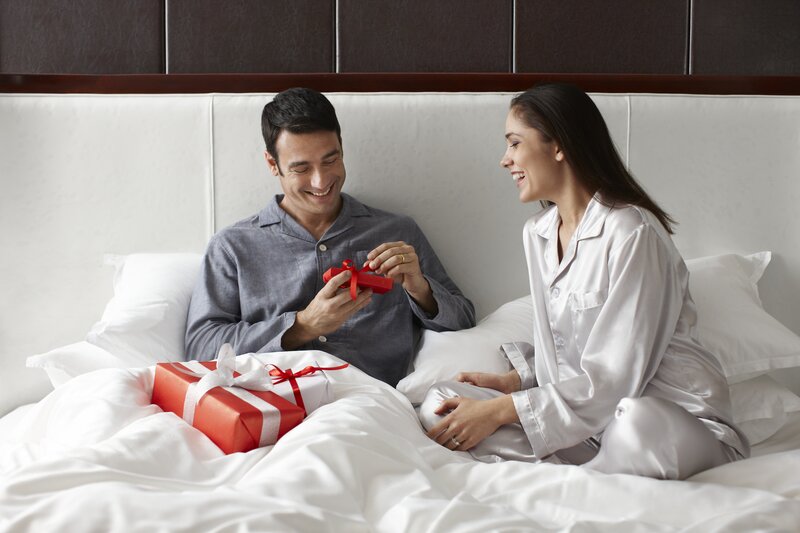 Couple in Bed with Gifts