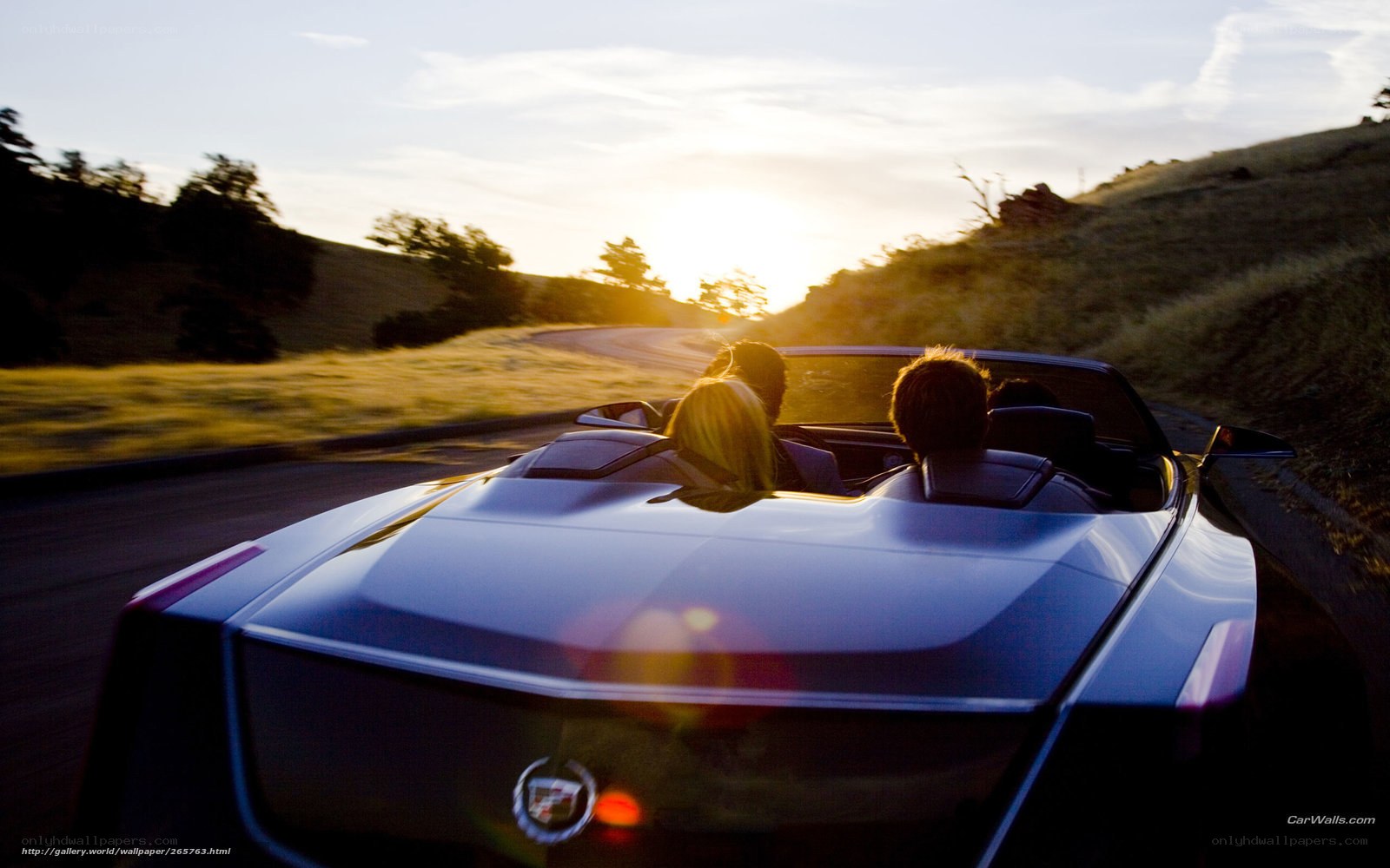 Couple in convertible at sunset