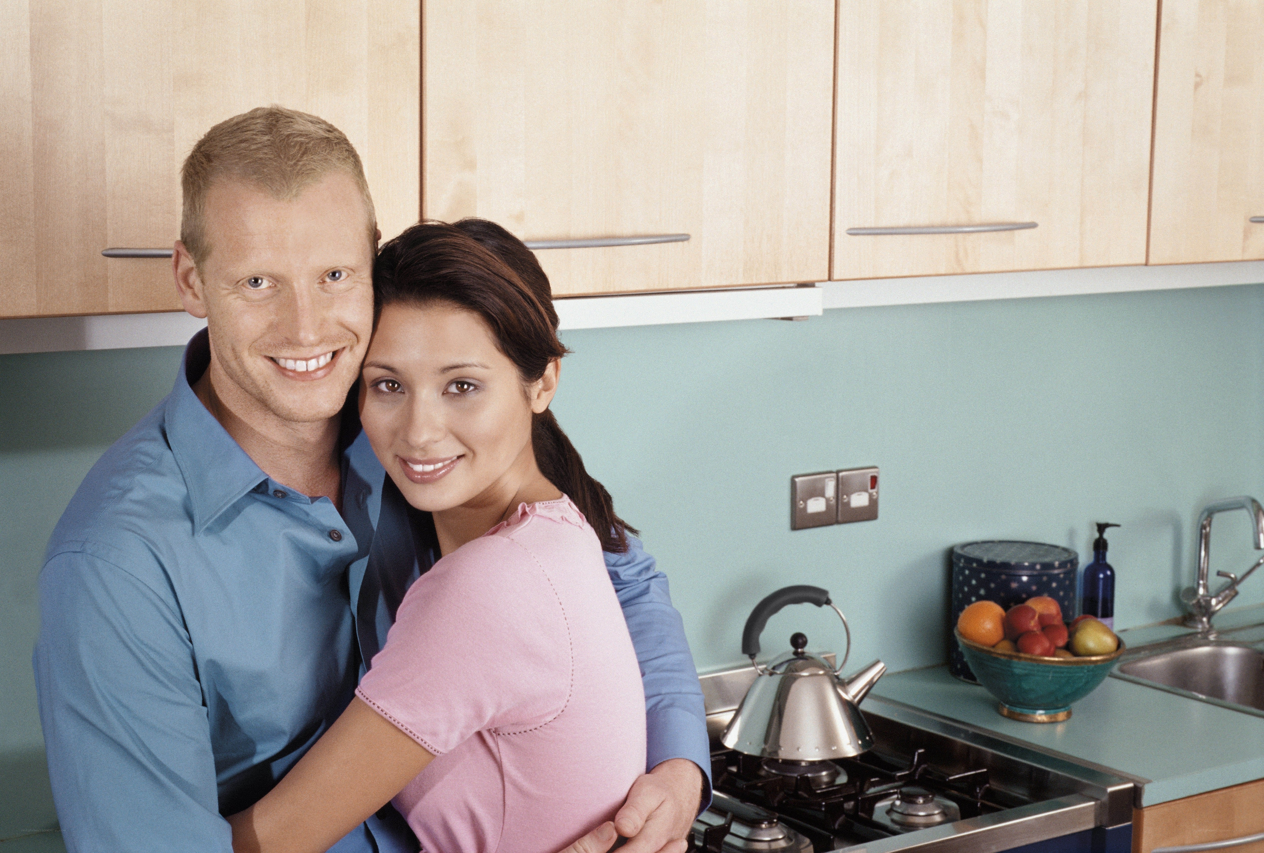 Couple in kitchen embrace