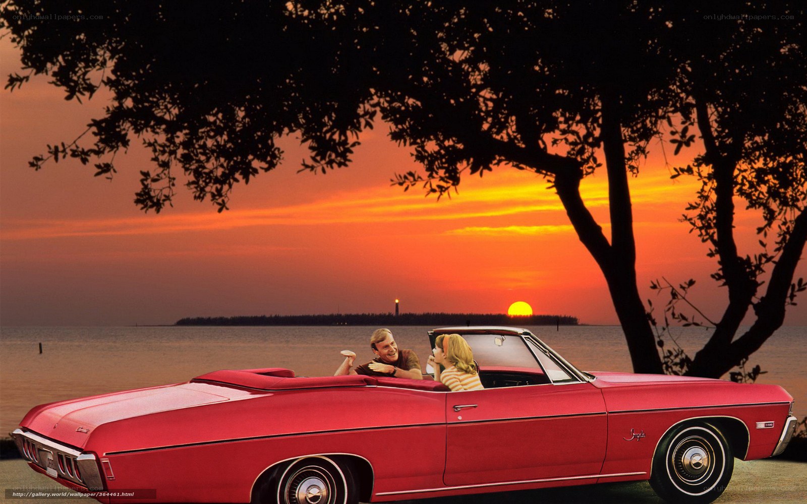 Couple in red convertible at sunset