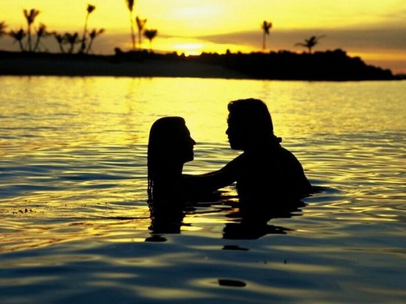 Couple in water at sunset