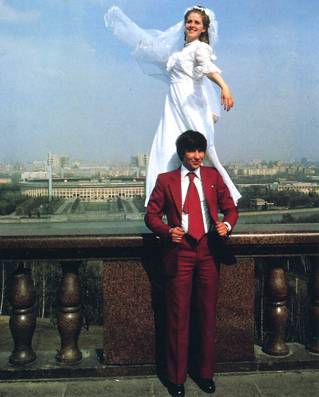 Couple in wedding attire on balcony