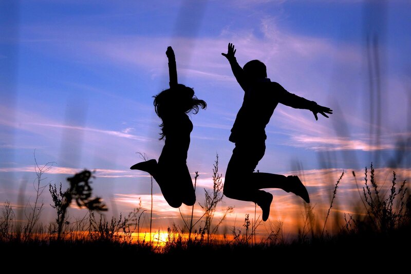 Couple jumping at sunset