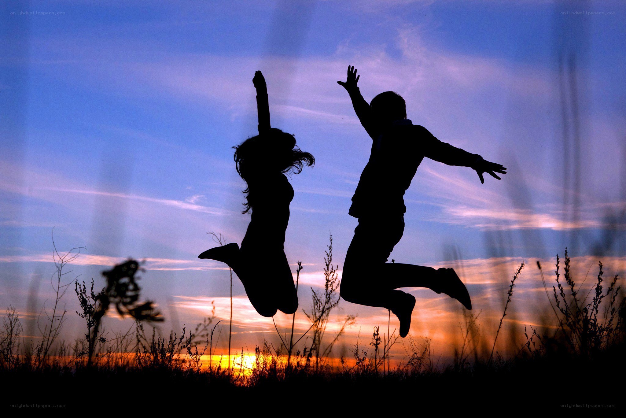 Couple jumping at sunset