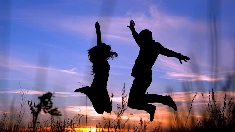 Couple jumping at sunset