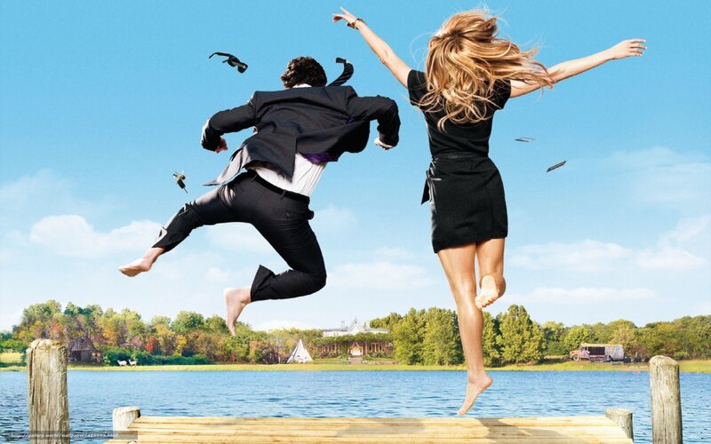 Couple jumping off dock