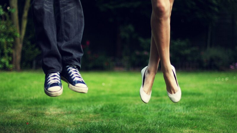 couple jumping on grass