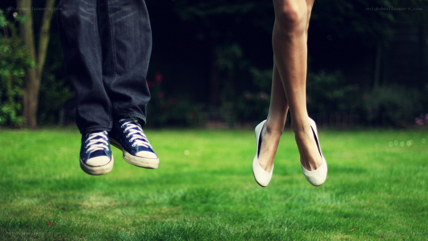 couple jumping on grass