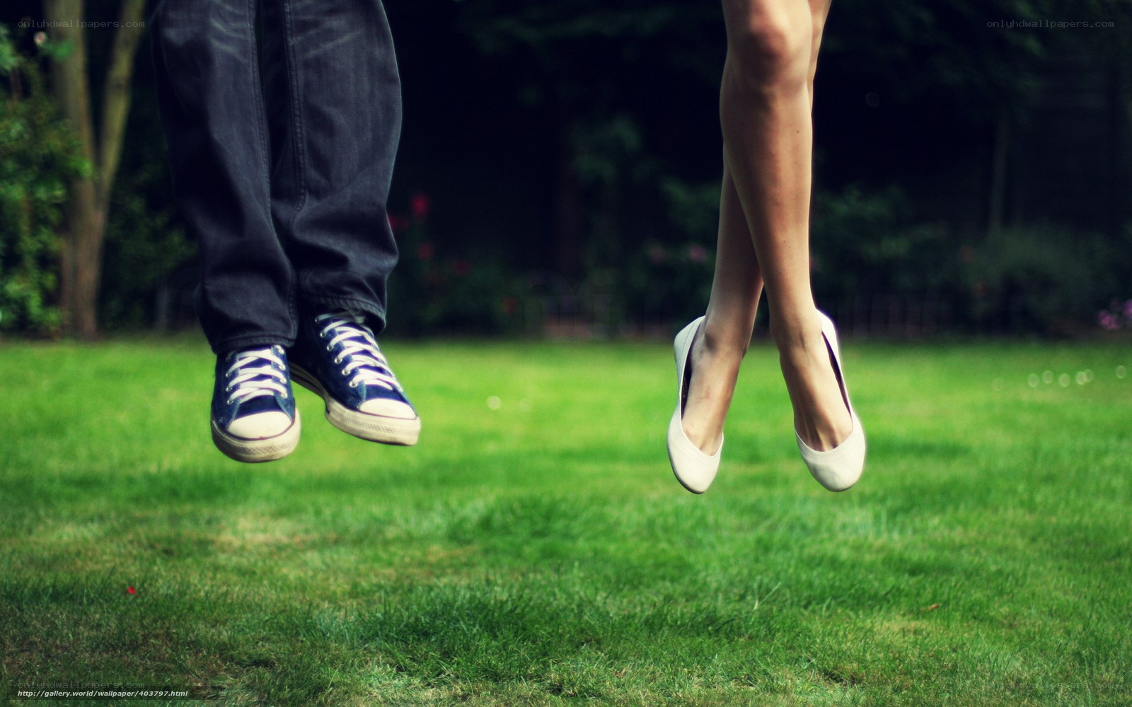 Couple jumping on grass