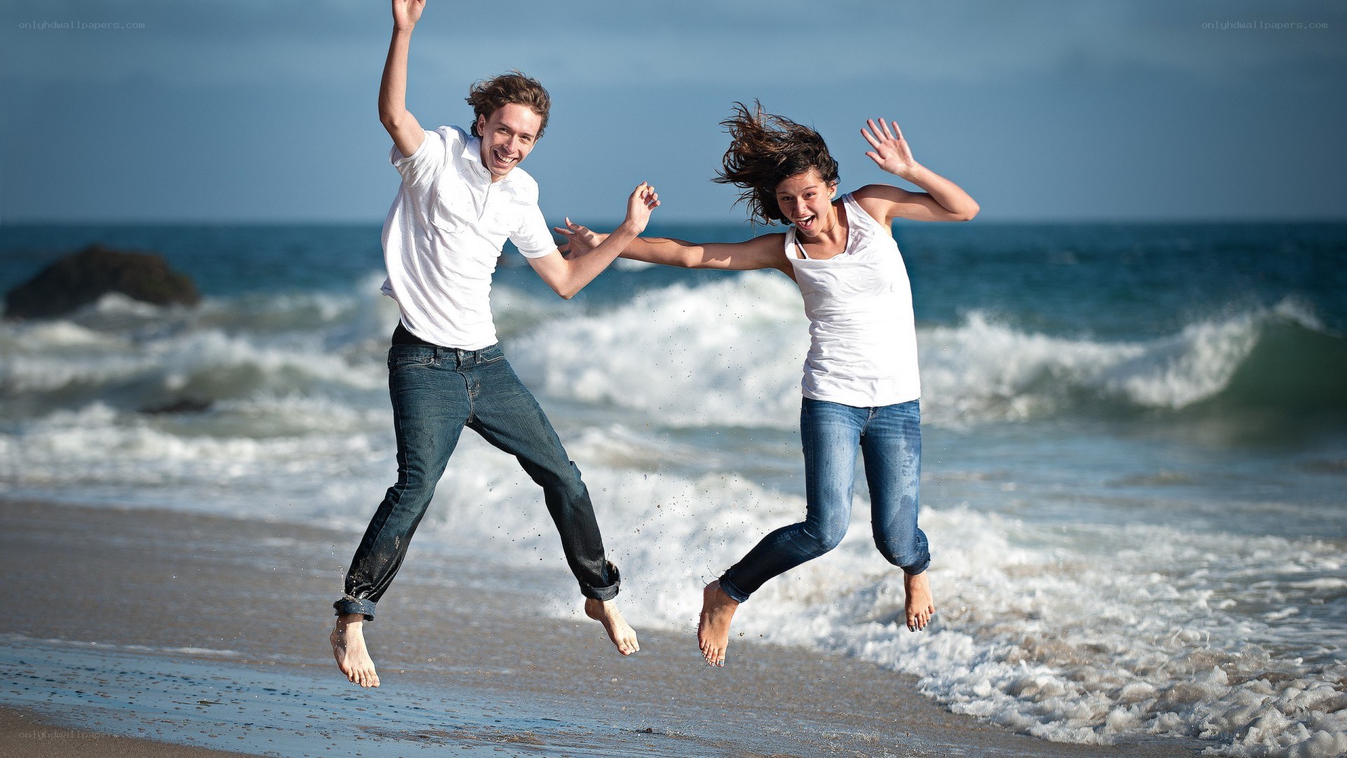 Couple jumping on the beach