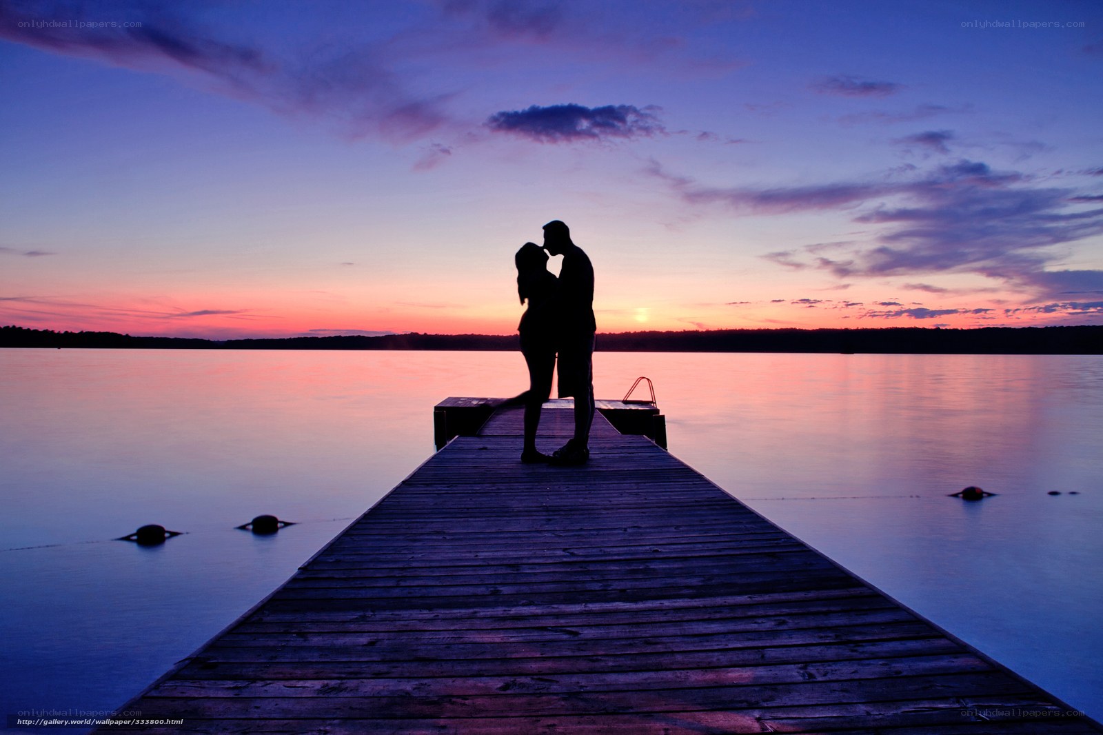 Couple kissing at sunset on dock