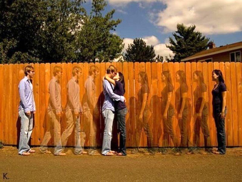 Couple kissing behind fence