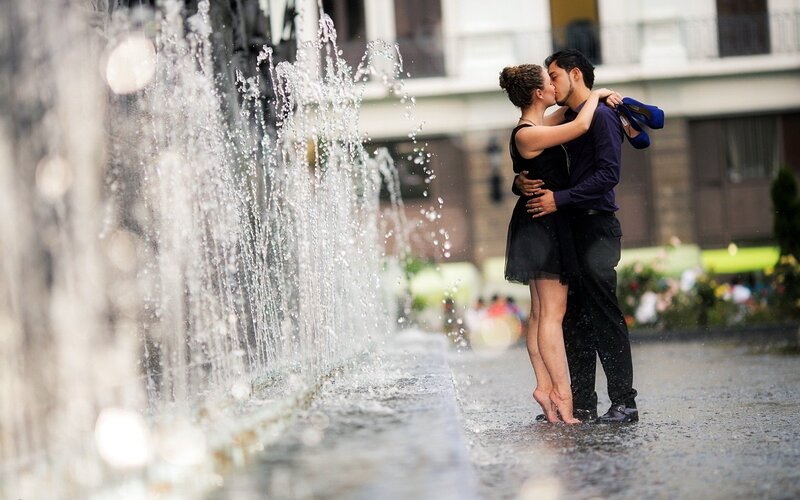 Couple kissing by a fountain