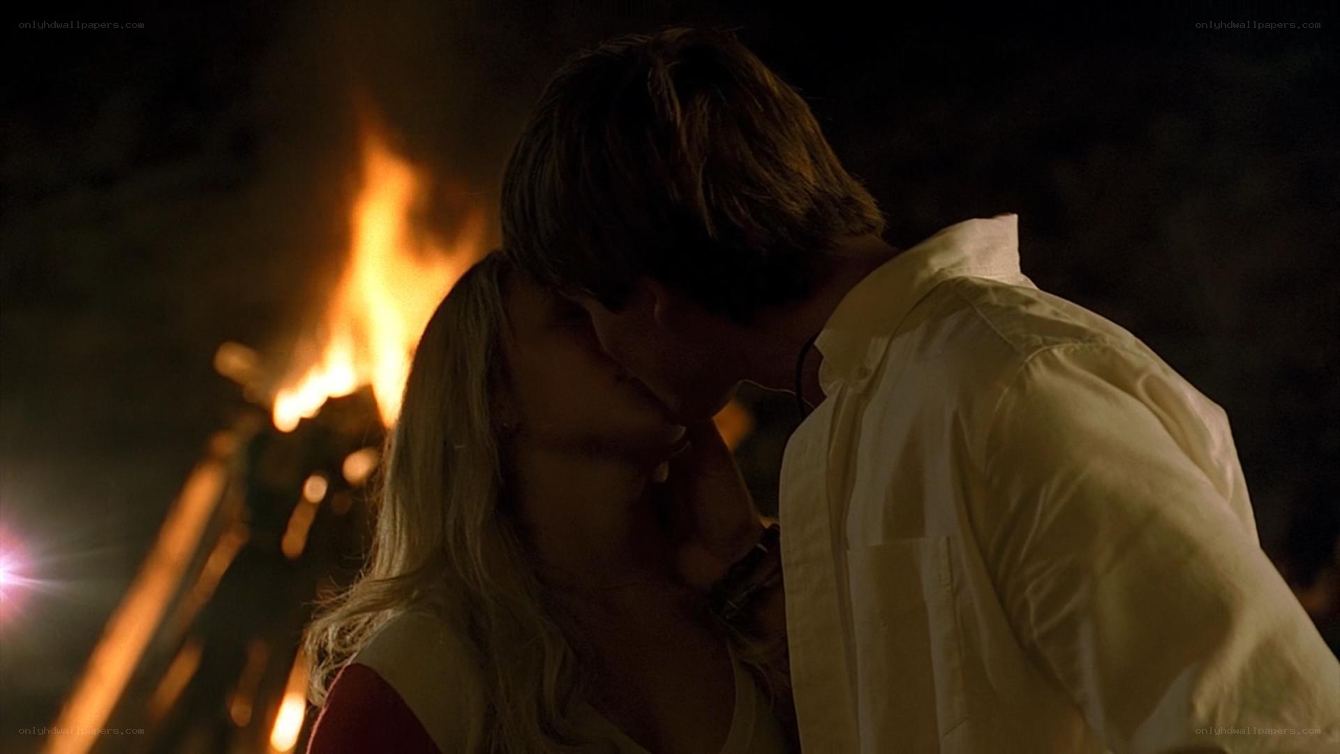 couple kissing by campfire