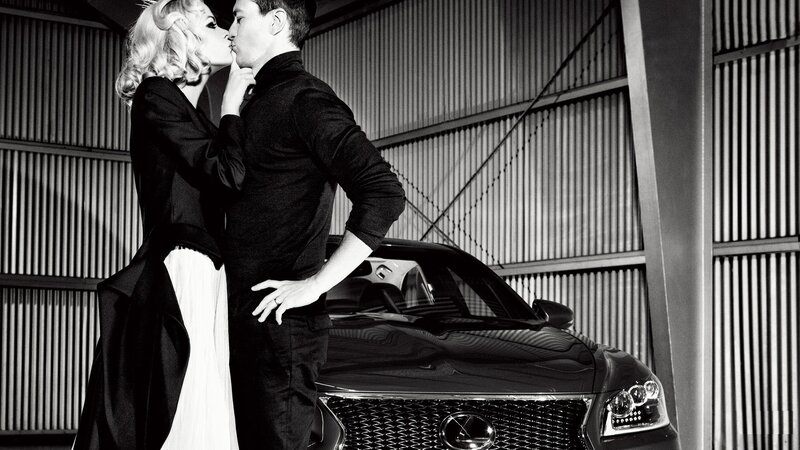Couple kissing by luxury car
