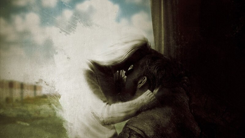 couple kissing by window