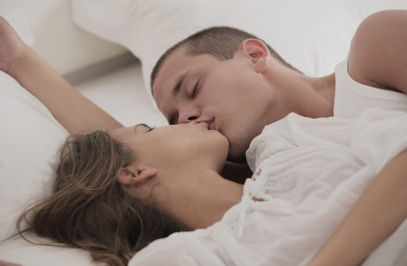 couple kissing in bed