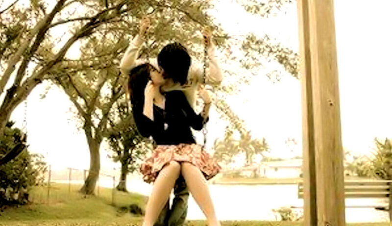 couple kissing on a swing