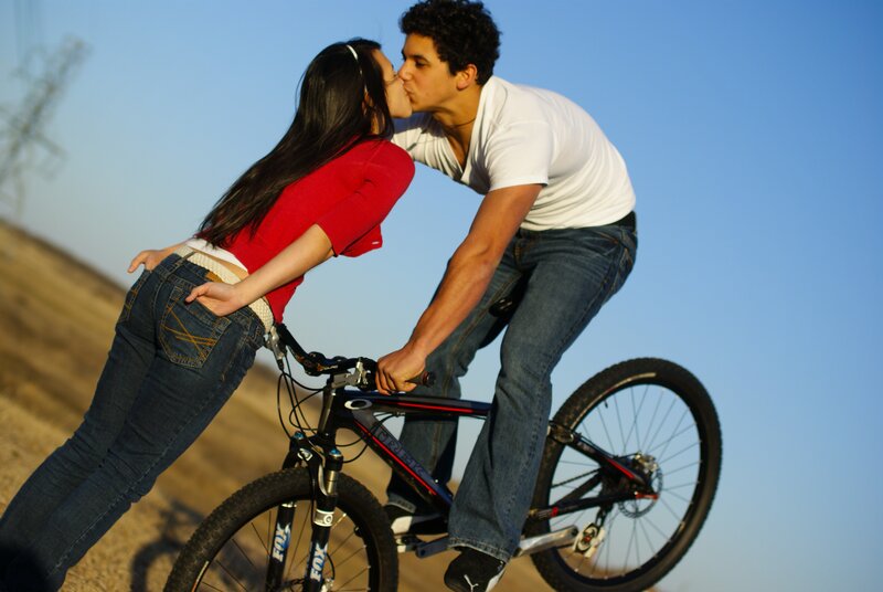 Couple kissing on bicycle