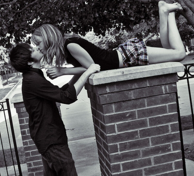 couple kissing on brick pillar