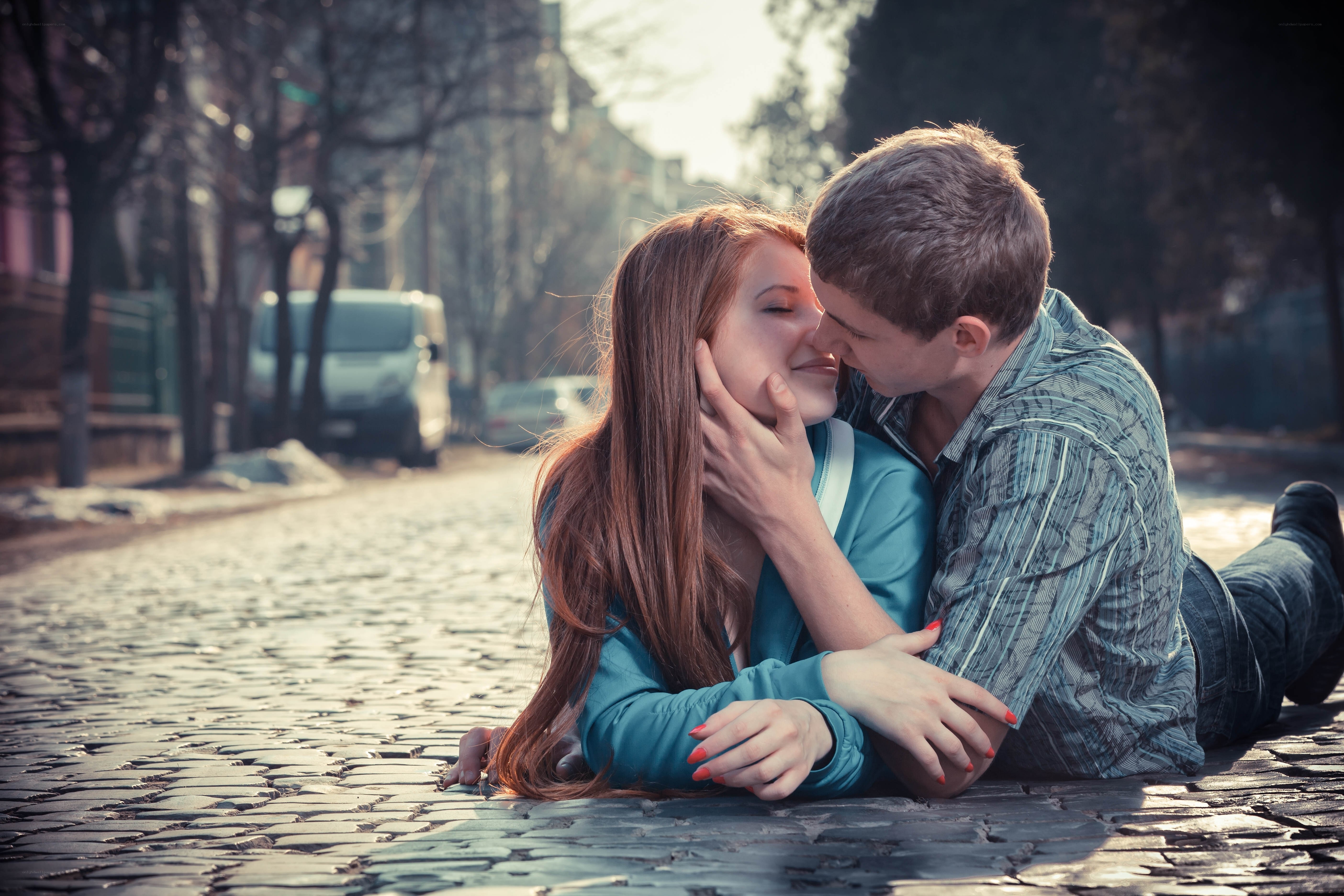 couple kissing on cobblestone