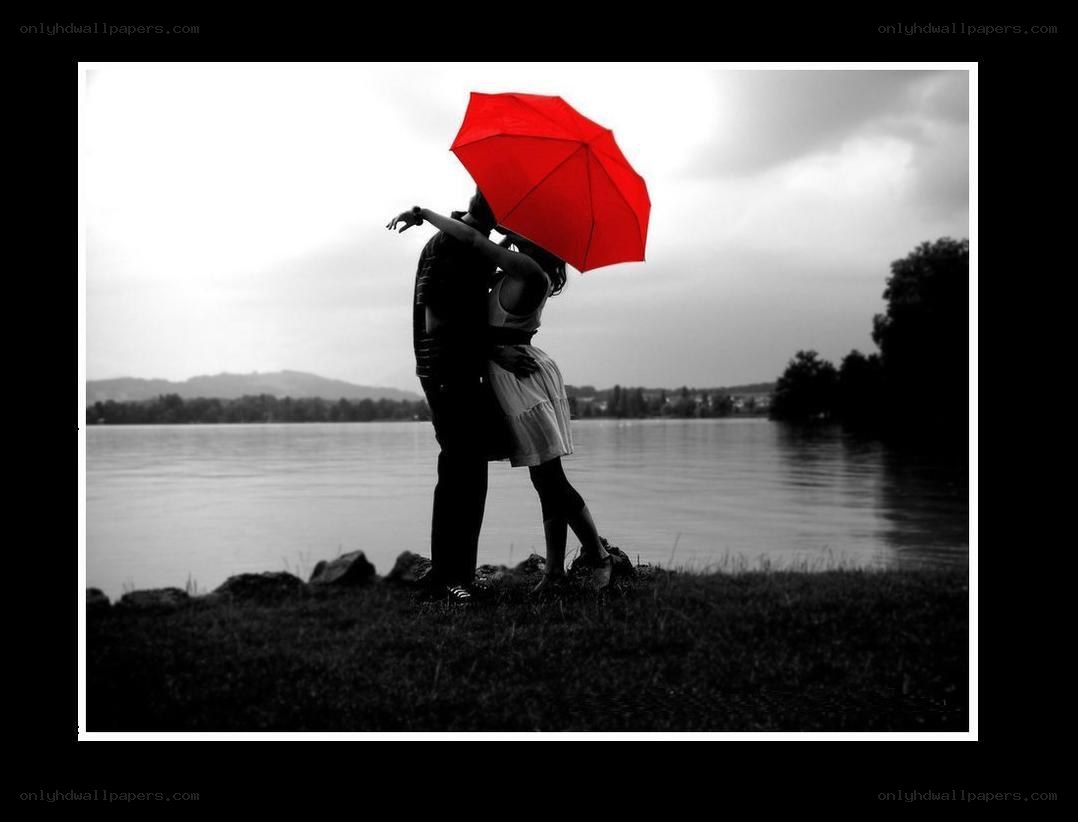 Couple kissing under red umbrella