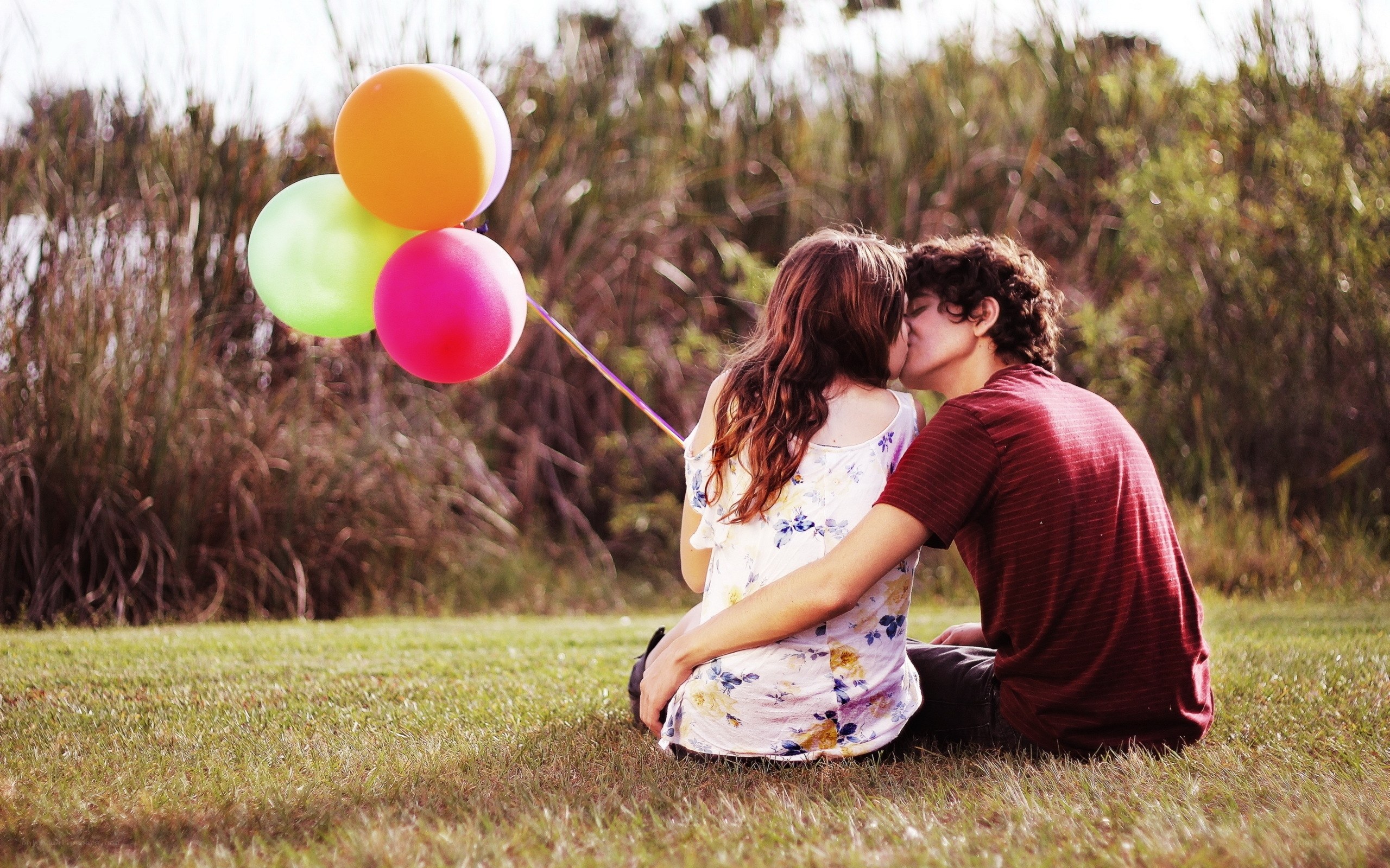 Couple kissing with balloons