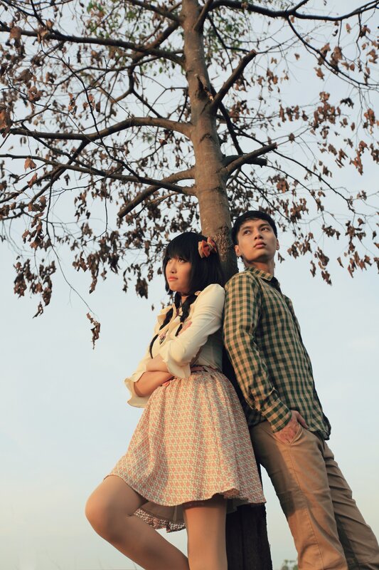 Couple leaning against a tree