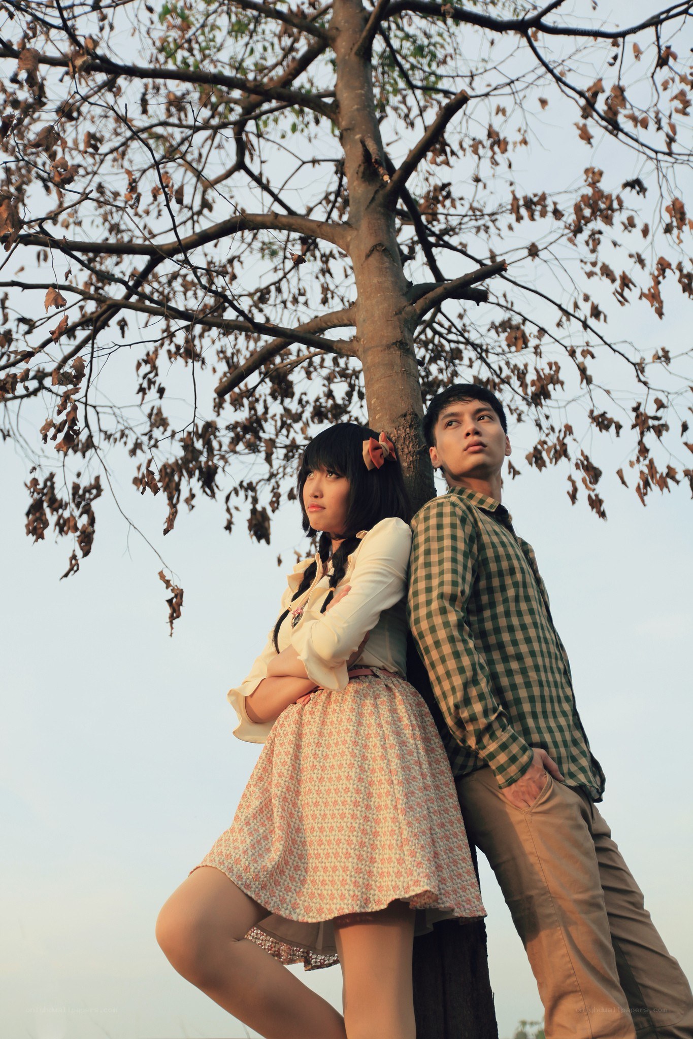 Couple leaning against a tree