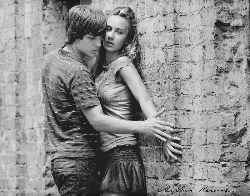 Couple Leaning on Brick Wall